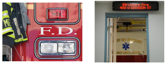 Fire engine beside a fire station LED message board displaying a structure fire alert above a doorway